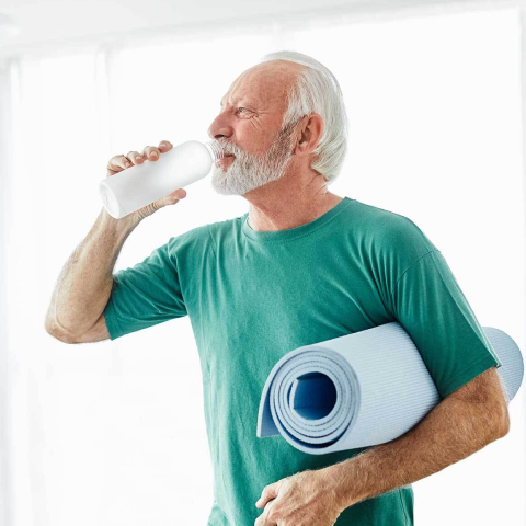 Elder man drinking from water bottle